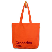 Orange Classic tote bag with Groceries Etc. text in burgundy