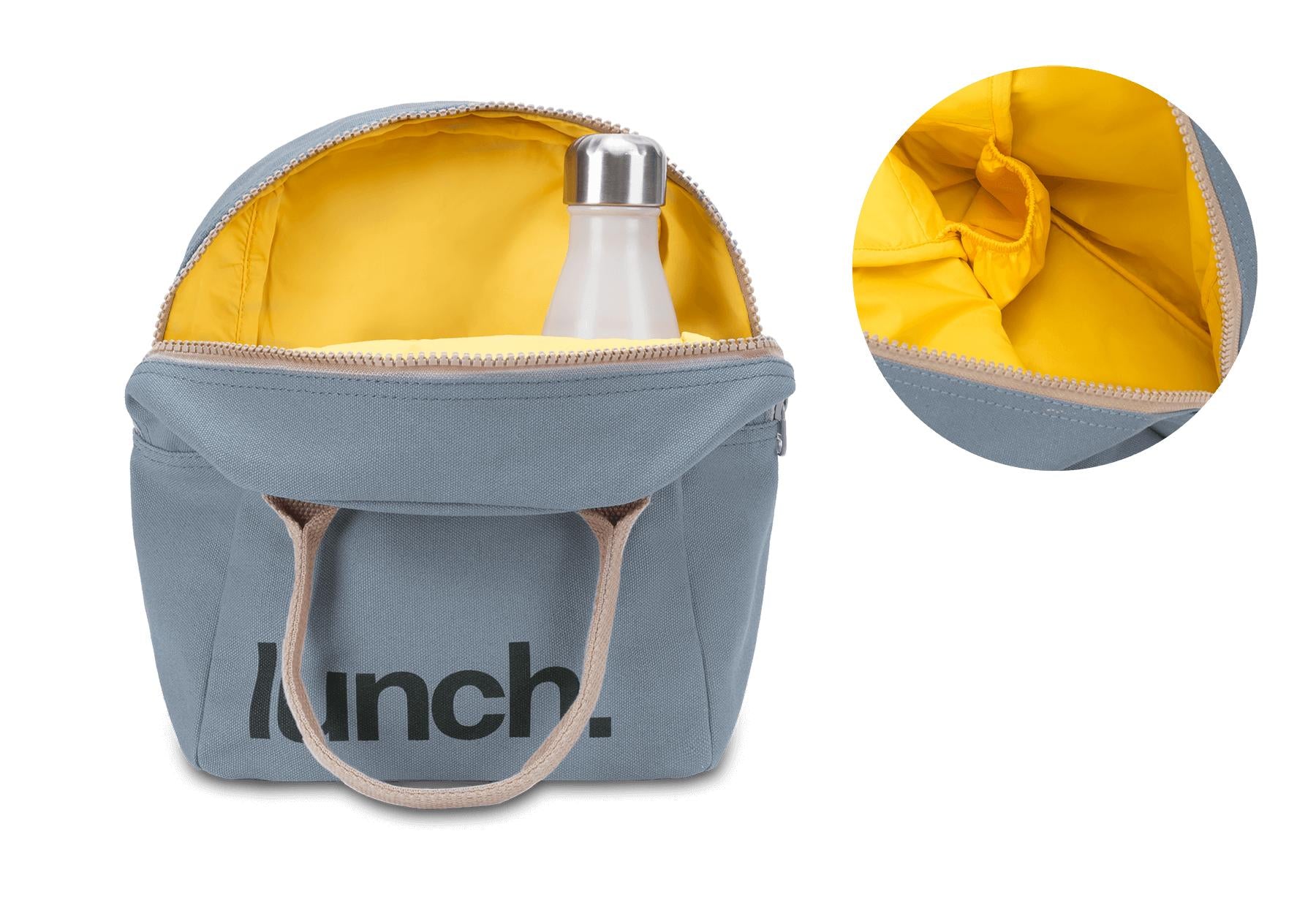 Fluf's blue zipper lunch bag features a playful black 'lunch' motif, natural color handles and yellow food safe lining
