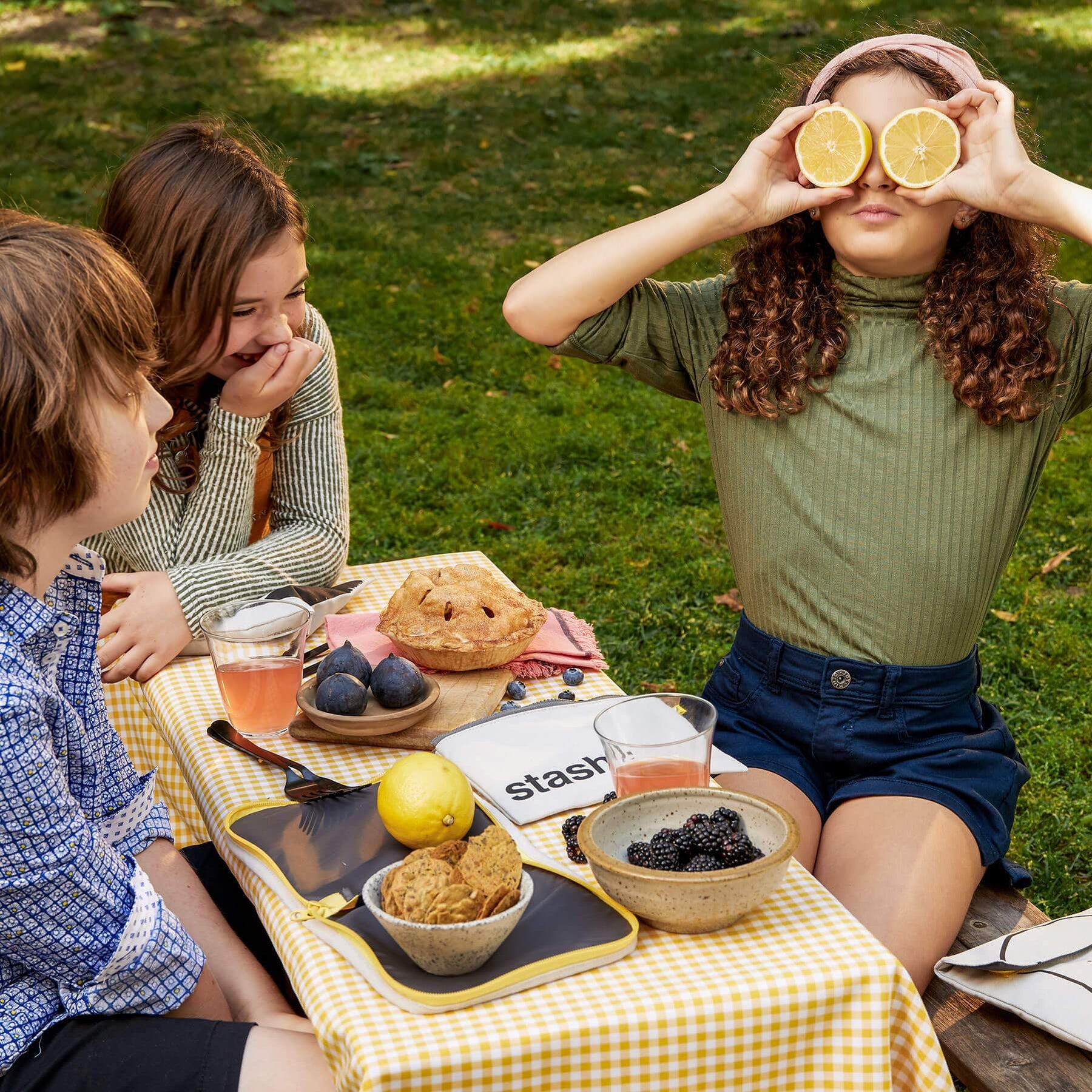 Bread Blue Snack Pack and snack bas on picnic table and kids seating around