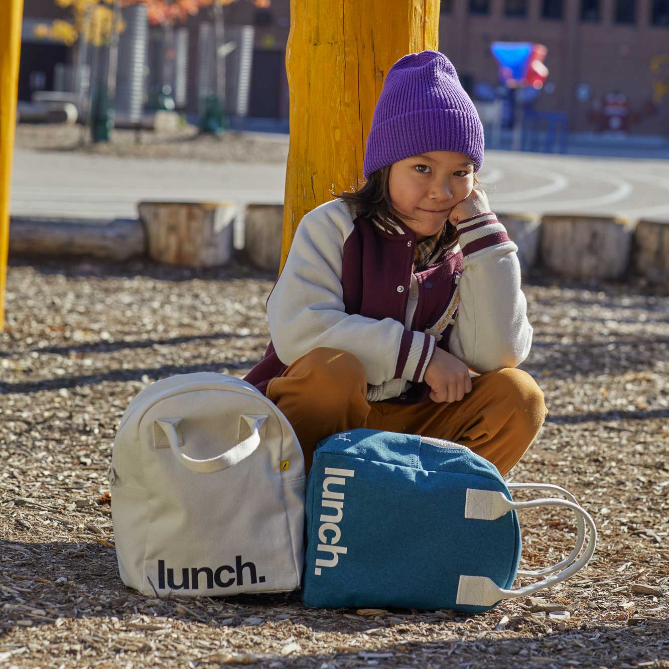 a boy with 2 lunch zipper lunch bags, white and Cypress colors. Great for kids and teens