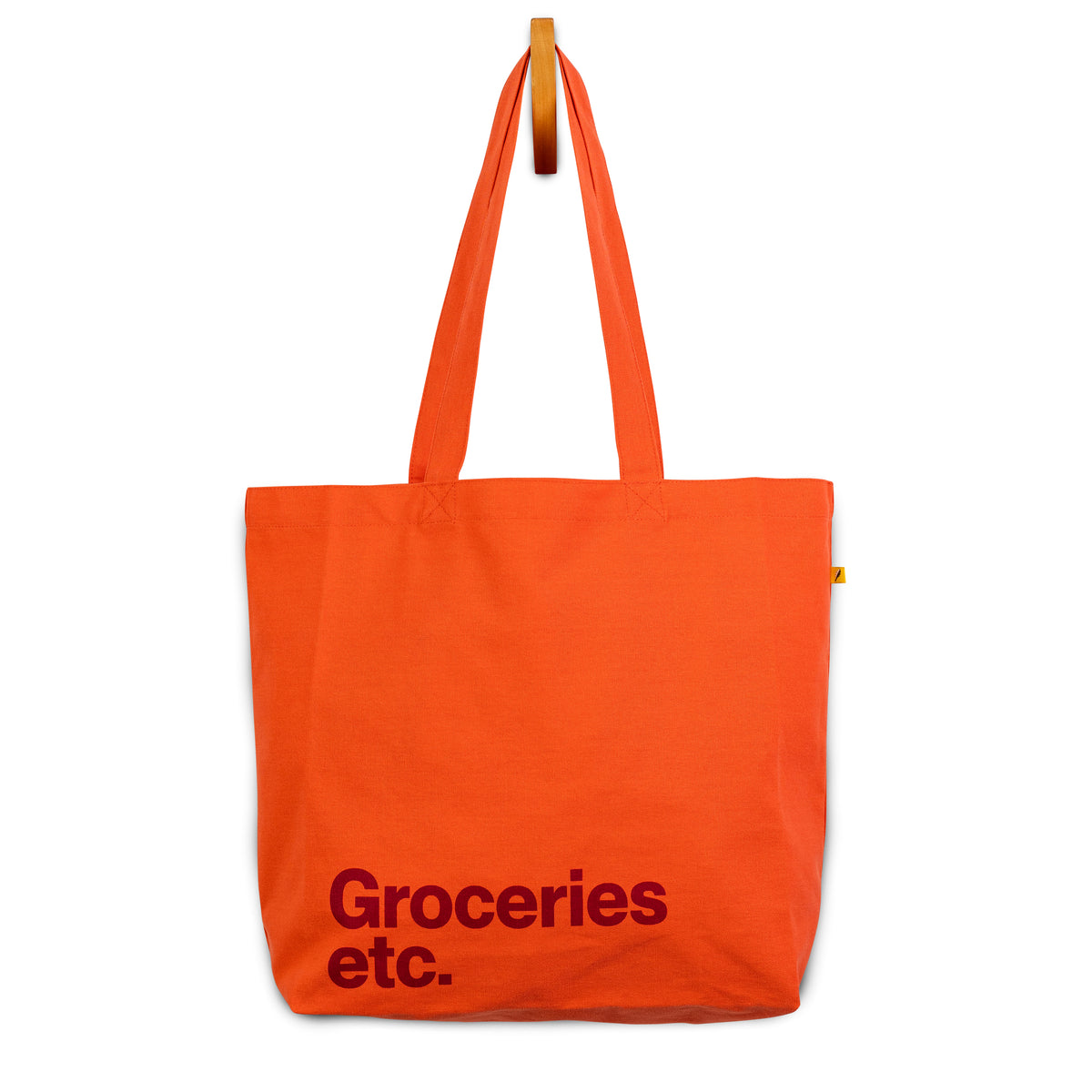 Orange Classic tote bag with Groceries Etc. text in burgundy