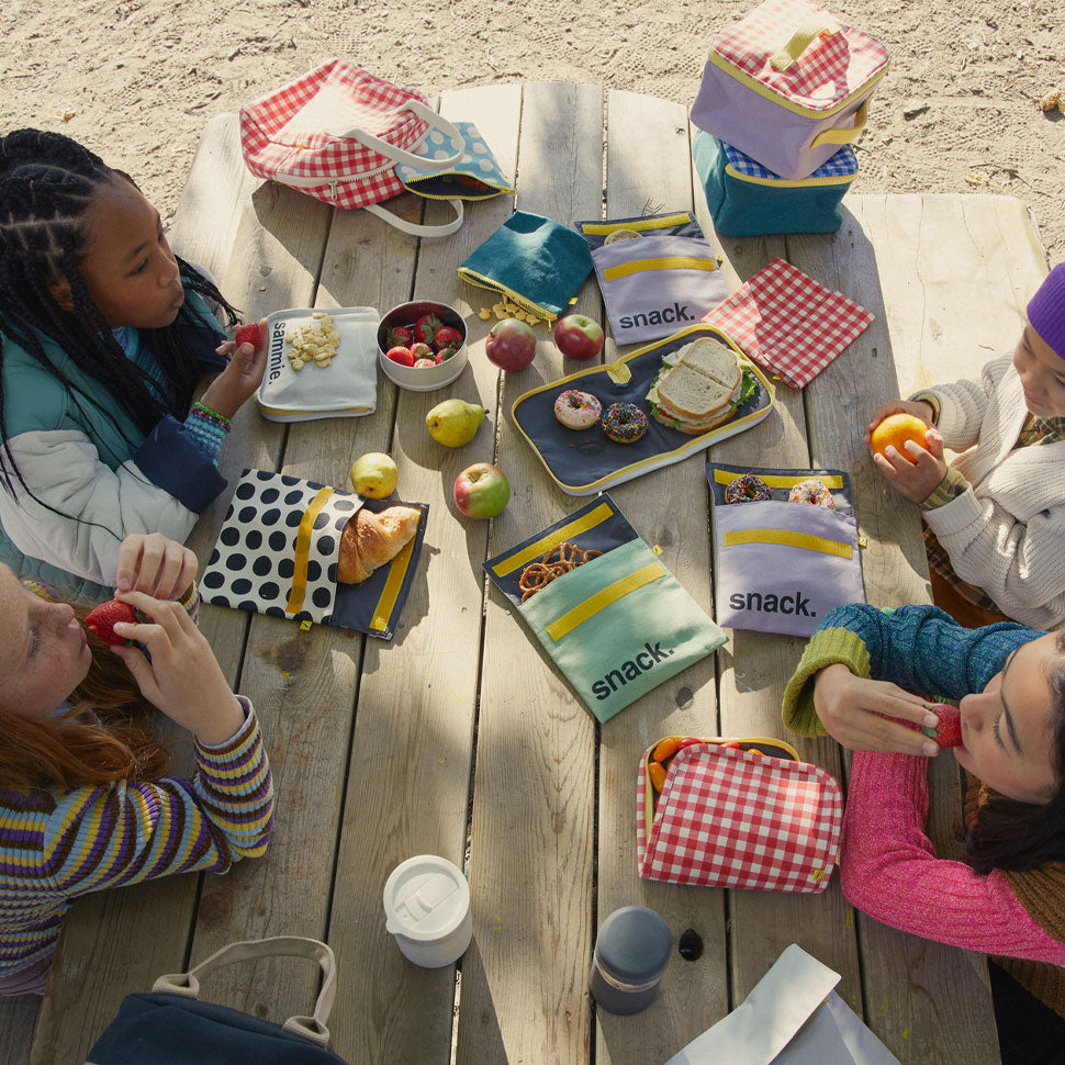 Kids eating fruits from snack bags and lunch boxes