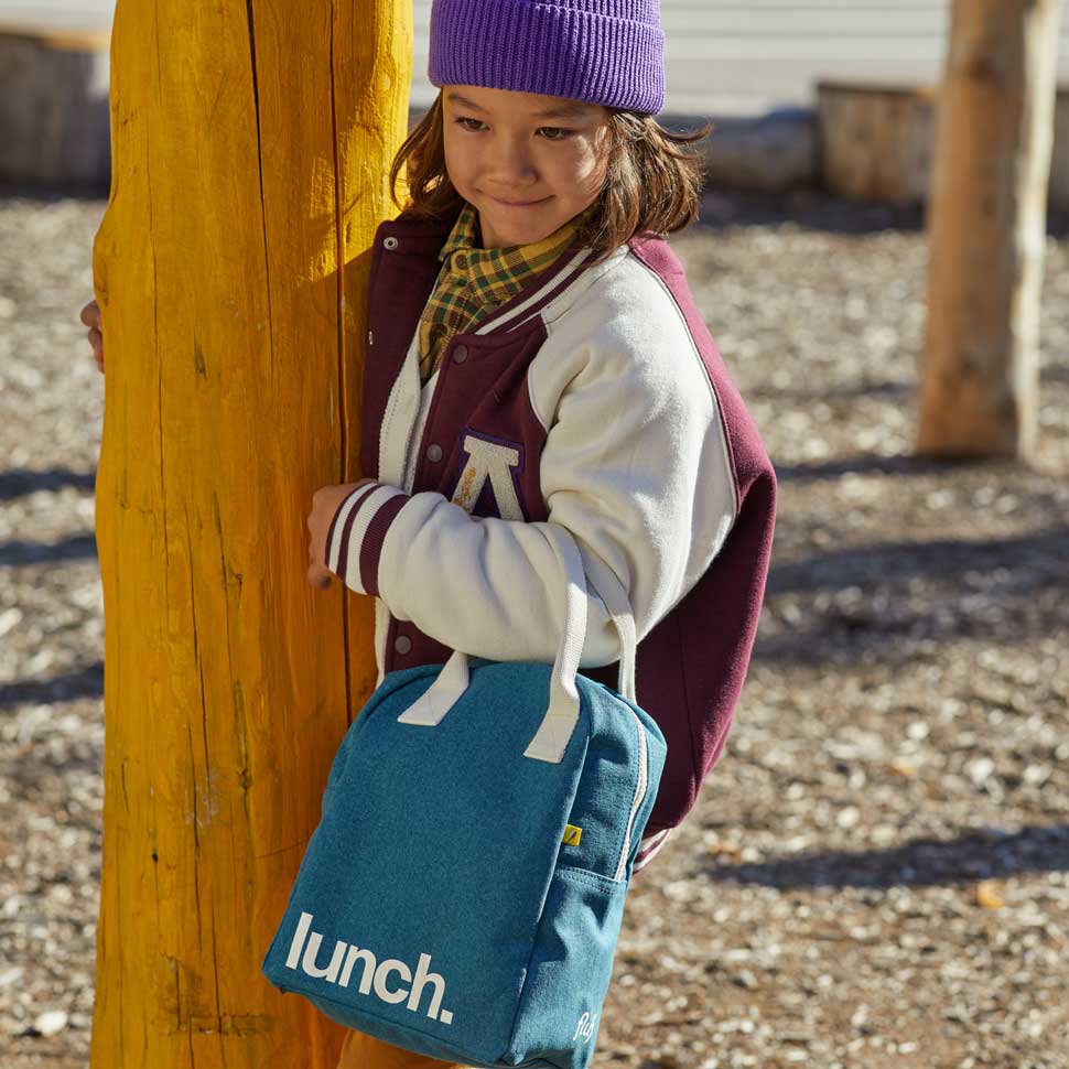 A boy holding Fluf's lunch bag 