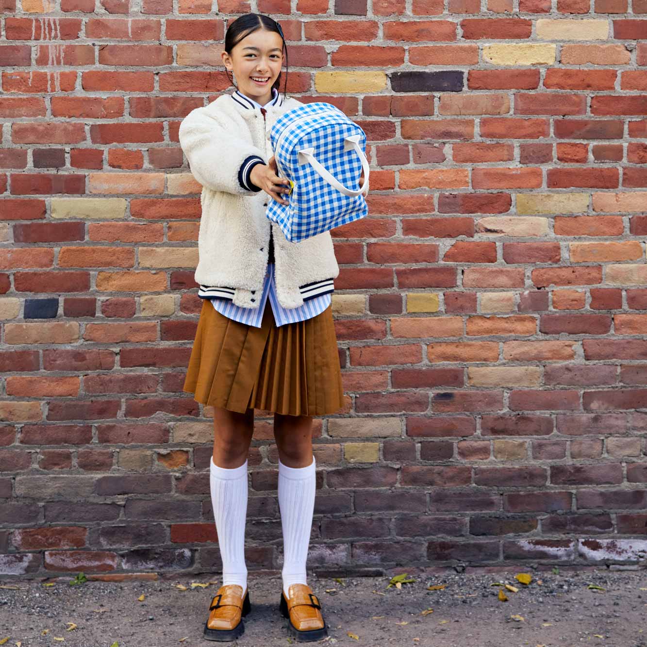 Teenage girl holding Fluf's Gingham Blue organic lunch bag